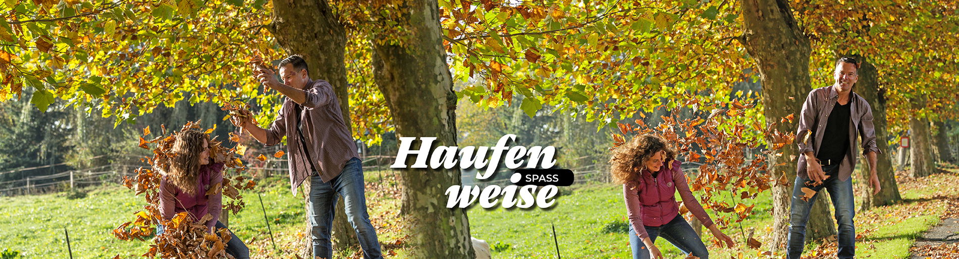 Mann und Frau bewerfen sich lachend mit  Laub